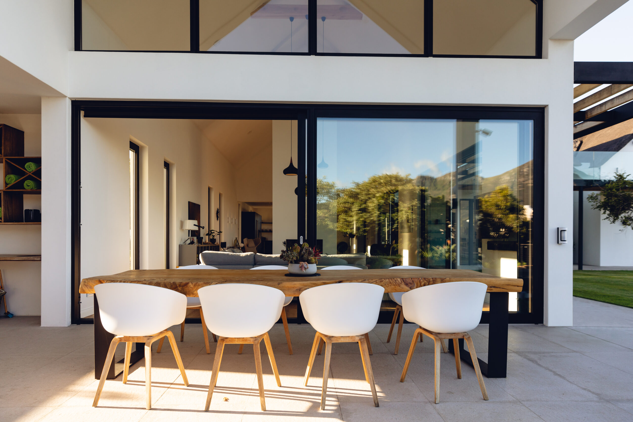 View of luxurious modern house exterior with dining space and garden. Modern architecture and designing concept